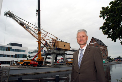 Foto zeigt historischen Kran in Kleve mit Landrat Wolfgang Spreen